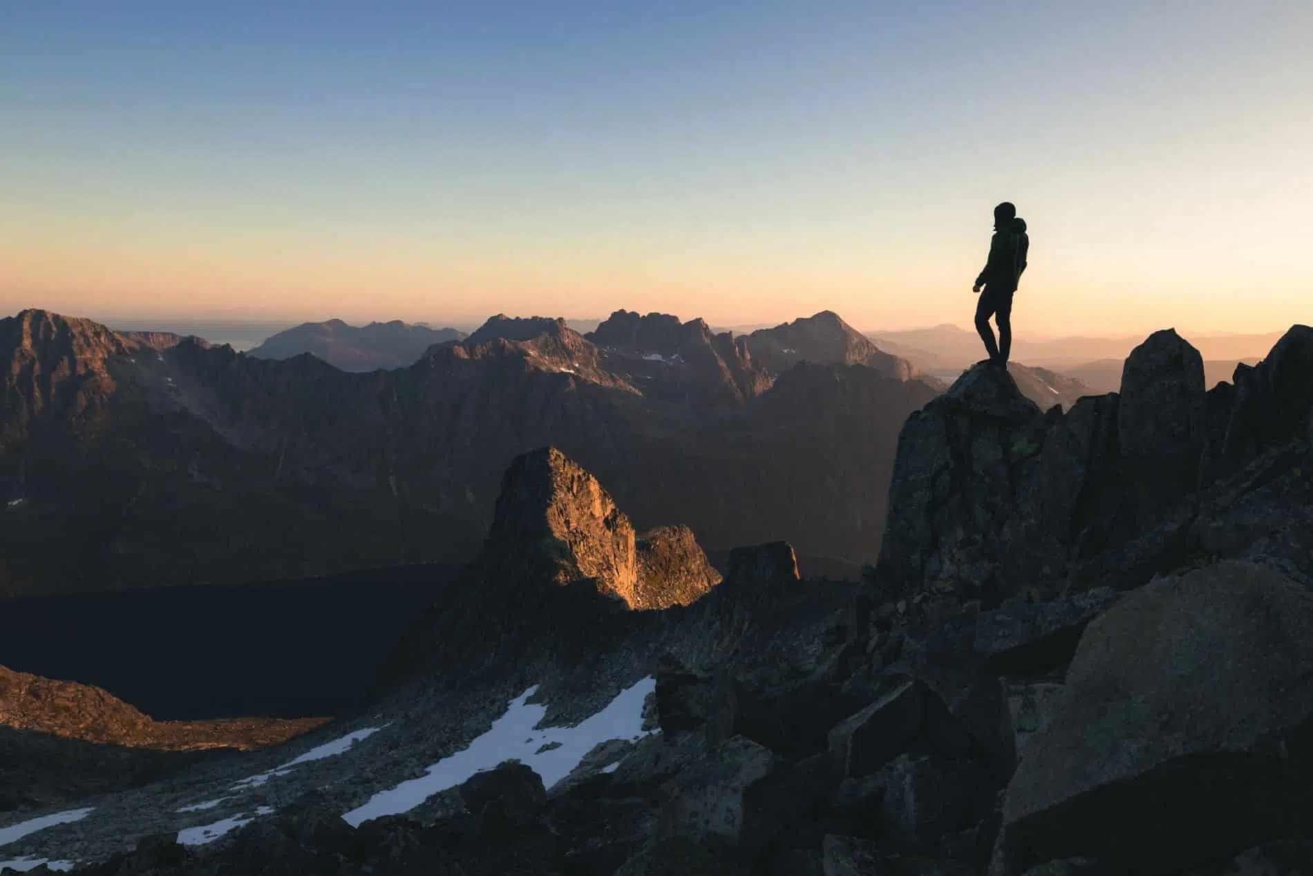 silhouette of person standing on the top of hill under the beautiful colorful sky in the morning scaled